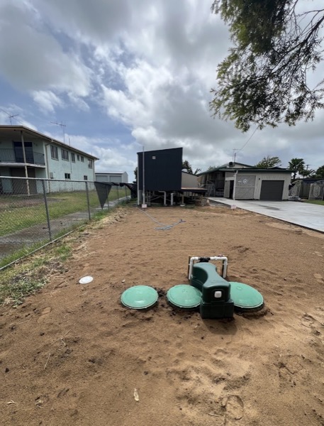 A wastewater treatment system installed and backfilled in a suburban yard