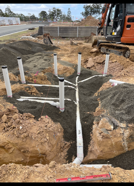 White drainage pipes set into a trench on a Bundaberg building site